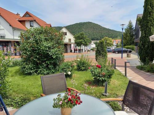 uma mesa de vidro com cadeiras e flores numa rua em Pension Bitter em Bad Wildungen