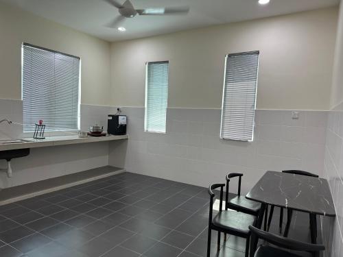 eine Küche mit einem Tisch, Stühlen und Fenstern in der Unterkunft 13A Homestay 14D in Port Dickson