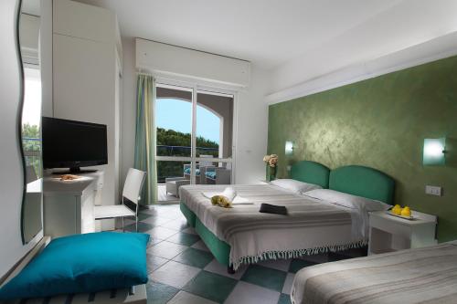 a bedroom with a large bed and a flat screen tv at Hotel Lido Europa in Riccione