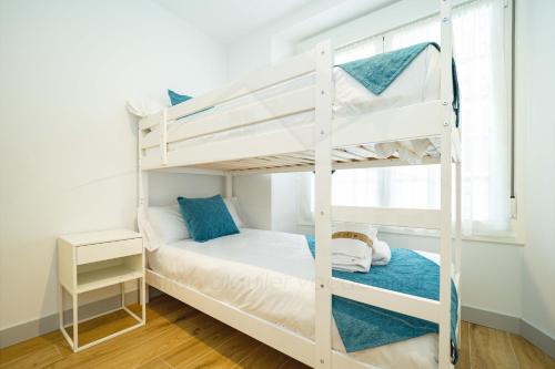 1 dormitorio con 2 literas y ventana en Casa Del Sol Apartamento, en Gijón