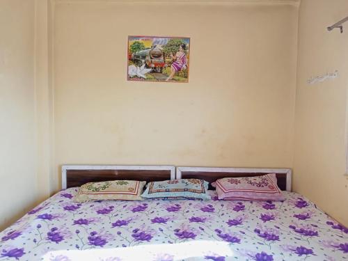 uma cama com duas almofadas e uma fotografia na parede em Shri Raam Homestay Sirmoli Bhatronjkhan em Bhatrojkhan