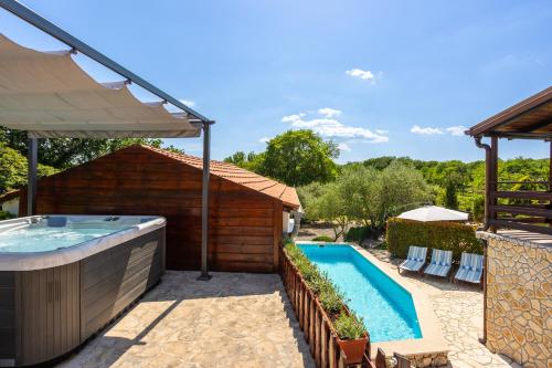 a swimming pool with a hot tub next to a building at Vila Marak in Risika