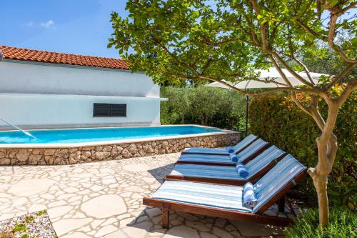 a bench sitting next to a swimming pool at Vila Marak in Risika