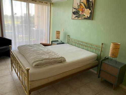 Una cama sentada en una habitación con ventana. en Joli appartement calme avec vue piscine, en Mandelieu-la-Napoule