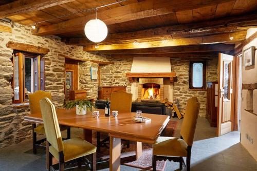 a dining room with a table and a fireplace at Wild Valley Puro Ticino 1+2 in Valle Onsernone in Crana