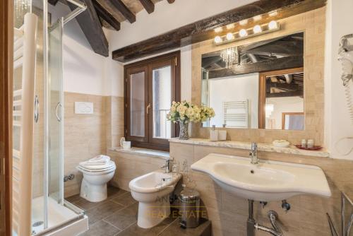 um banheiro com uma pia, um vaso sanitário e um espelho em Apartment by The Spanish Steps em Roma