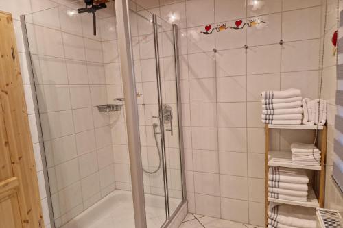 La salle de bains est pourvue d'une cabine de douche et de serviettes blanches. dans l'établissement Ferienhaus LandMeer, à Gödenstorf