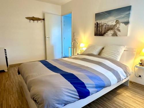 une chambre avec un lit avec un tableau sur le mur dans l'établissement Appartement proximité mer, à Saint-Gilles-Croix-de-Vie
