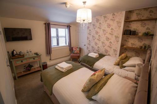 a bedroom with two beds and a window at The Royal George in Cottingham