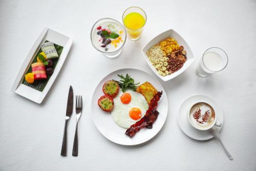 a white table with a plate of food with eggs and bacon at DoubleTree by Hilton Hotel Anshun in Anshun