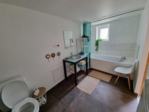 uma casa de banho com uma banheira, um WC e um lavatório. em Maison Oscar et Petrus em Beaumont-du-Gâtinais
