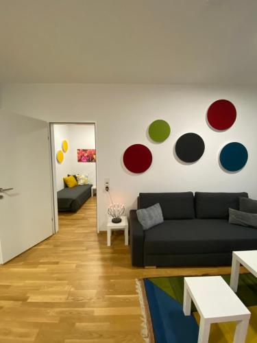 a living room with a black couch and a painting on the wall at Ebelsberger Terrassen in Linz