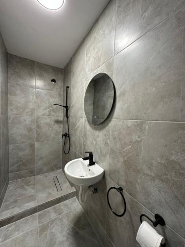 La salle de bains est pourvue d'un lavabo et d'un miroir. dans l'établissement Vila Athos 2, à Voluntari
