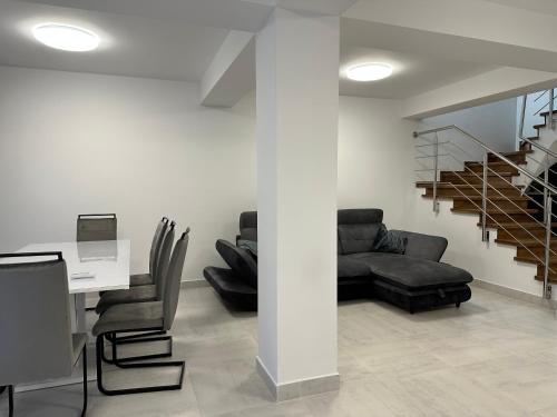 - un salon avec une table, un canapé et des escaliers dans l'établissement Vila Athos 2, à Voluntari