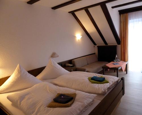 ビショフスハイム・アン・デア・レーンにあるPension Gasthof Zum Lammのベッド2台とソファが備わるホテルルームです。