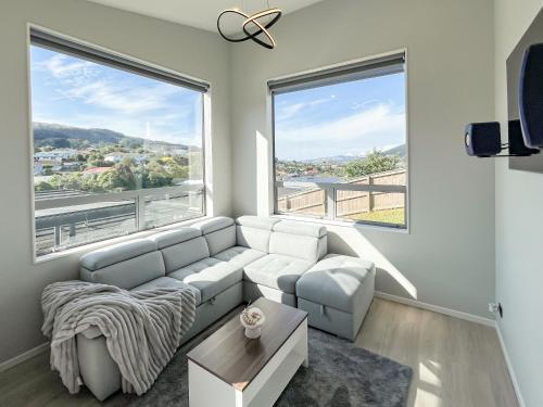 a living room with a couch and two large windows at The Lodge @ Pembroke in Wellington