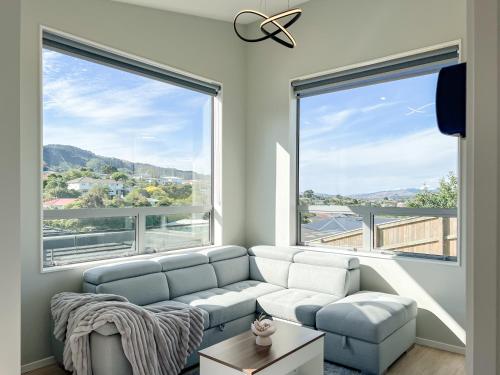 a living room with a couch and two large windows at The Lodge @ Pembroke in Wellington