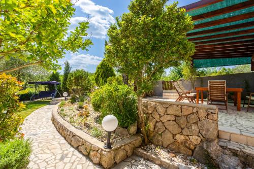 a garden with a stone wall and a patio at Vila Marak in Risika
