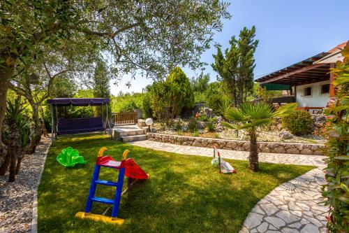 a yard with a playground with a blue ladder at Vila Marak in Risika