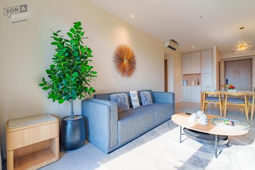a living room with a blue couch and a table at Son&Henry Zenity District 1 in Ho Chi Minh City