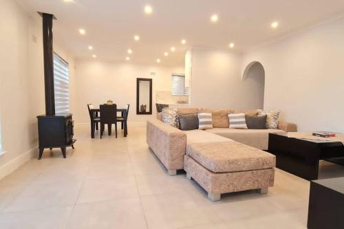 een woonkamer met een bank en een tafel bij Villa Lamsyh- your second home in Kaapstad