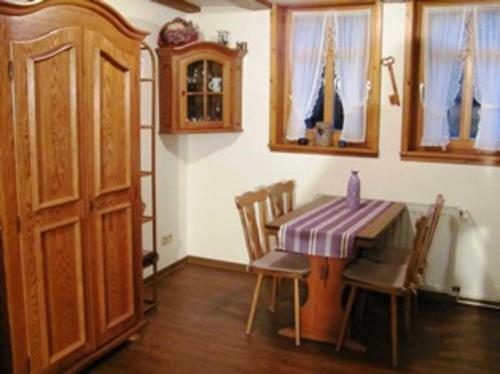 a dining room with a table and chairs and a door at Ferienwohnung im ältesten Fachwerkhaus in Blankenburg