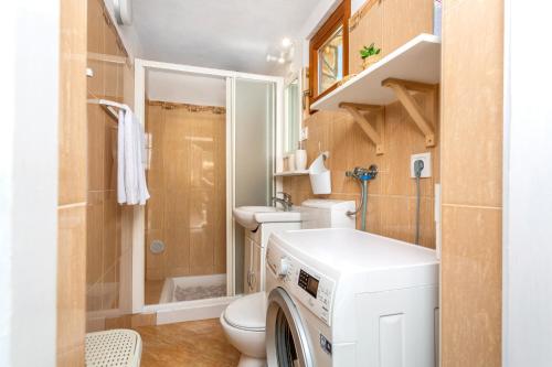 a small bathroom with a washer and dryer in it at Vila Marak in Risika