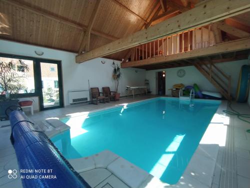 una piscina en una casa con techo de madera en Au Nid d'Amour, 