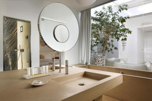 a bathroom with a large mirror and a sink at Palazzo Montemartini Rome, A Radisson Collection Hotel in Rome
