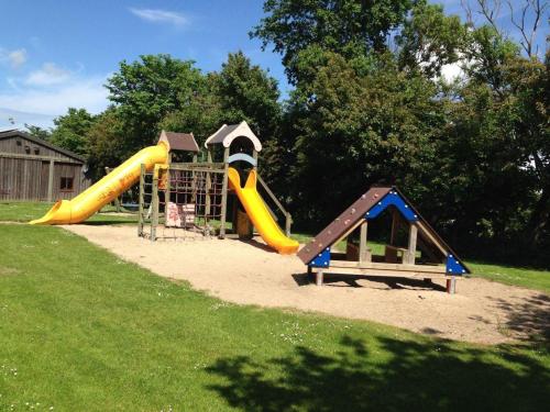 a playground with two slides and a play structure at Wohnung-Herzmuschel-im-Haus-Muschelgarten in Alkersum