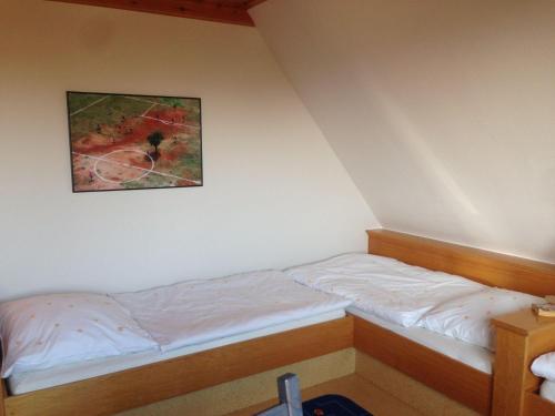 a bed in a room with a picture on the wall at Ferienwohnung-Schwertmuschel-im-Haus-Muschelgarten in Alkersum