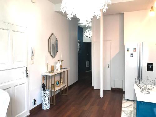 un salon avec un lustre et un couloir dans l'établissement LE PATIO LAFAYETTE - Hyper Centre - Proche Thermes - Luxe, à Vichy