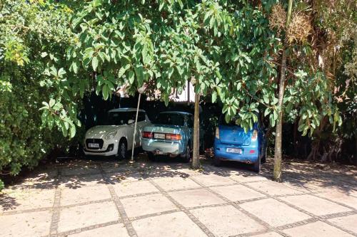 two cars parked under trees in a driveway at Bentley on the Beach in Umhlanga