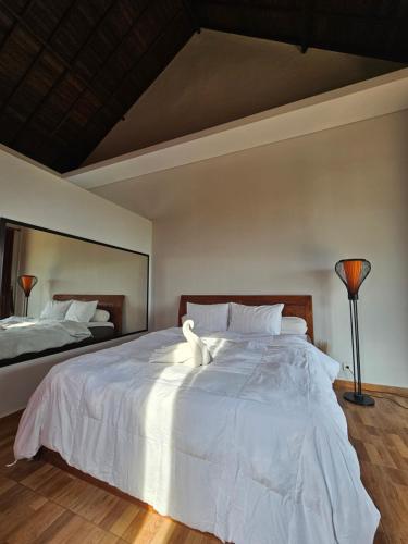 1 dormitorio con 1 cama grande con sábanas blancas en Pondok wina bedugul, en Bedugul
