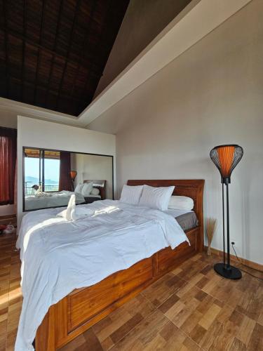 1 dormitorio con 1 cama grande con sábanas blancas en Pondok wina bedugul, en Bedugul