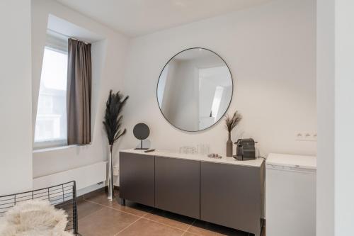 a bathroom with a sink and a mirror on the wall at Maison Bruges in Bruges