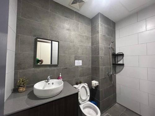 a bathroom with a sink and a toilet and a mirror at The Podium Studio@Amy*Home in Kuching