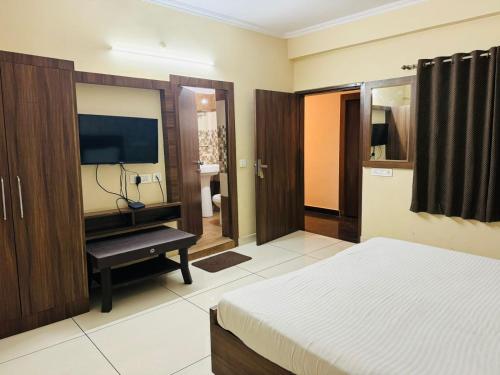 a bedroom with a bed and a flat screen tv at Hotel Pearl inn in Rudrapur