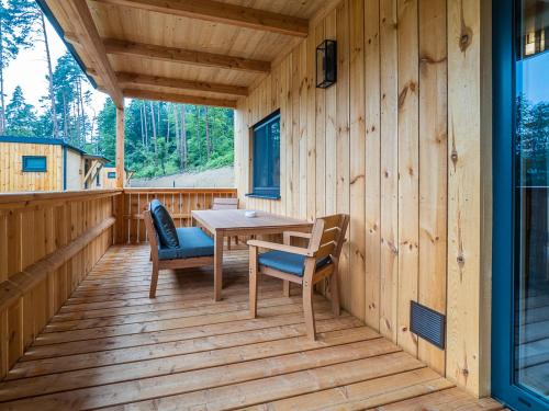 a wooden deck with a table and chairs on it at Seehäuser Dobra 