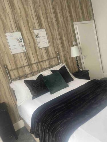 a bedroom with a bed with black and white pillows at Cosy modern one bedroom flat in Hartlepool