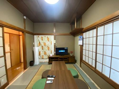 a living room with a table and a tv at 【浅草・秋葉原・銀座・スカイツリー・東京タワー他直通！】最大8人 in Tokyo