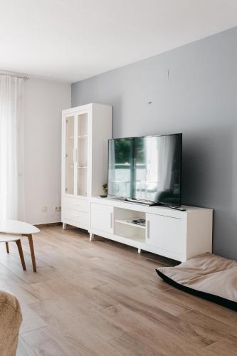 a living room with a tv on a white cabinet at Hauzify I Apartament Arroyo in Platja d'Aro