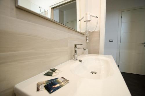 um lavatório branco na casa de banho com um espelho em Sea Salt em Porto Cesareo