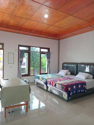 um quarto com 2 camas e uma mesa em Matraville guesthouse em Tuktuk Siadong