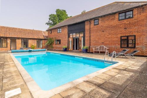 a swimming pool in front of a brick building at Semer Barn in Semer