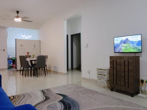 ein Wohnzimmer mit einem Tisch und einem TV an der Wand in der Unterkunft Homestay Damai D'Simfoni Kajang- Semenyih in Semenyih