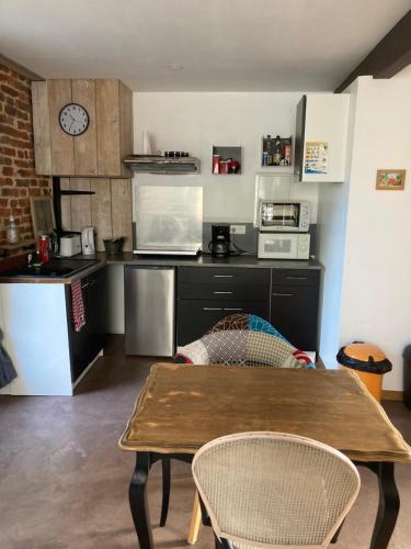eine Küche mit einem Tisch und einer Arbeitsplatte in der Unterkunft appartement terrasseLouhans centre in Louhans