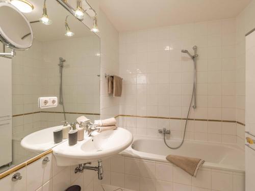 a bathroom with a sink and a shower and a tub at Blick auf's Schloss in Itter