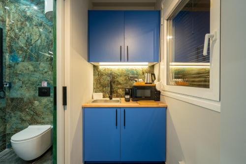 a small bathroom with blue cabinets and a sink at Syntagma Bliss: Athens Hub in Athens