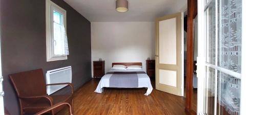 une chambre avec un lit et une chaise dedans dans l'établissement VILLA 250 M PLAGE QUARTIER PARC JARDIN GARAGE - Réf 130, à Royan